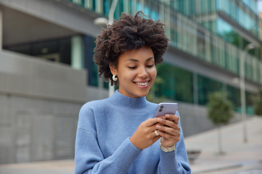 feliz-jovem-com-cabelo-espesso-e-encaracolado-que-faz-downloads-modernos-de-celulares (2)